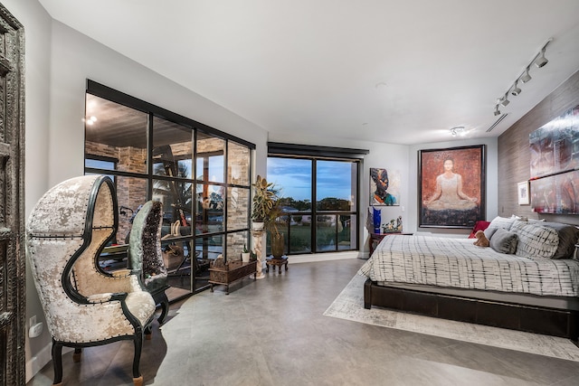 bedroom with concrete flooring and track lighting