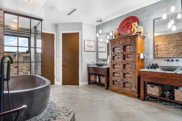 bathroom featuring vanity, concrete floors, and a bathing tub