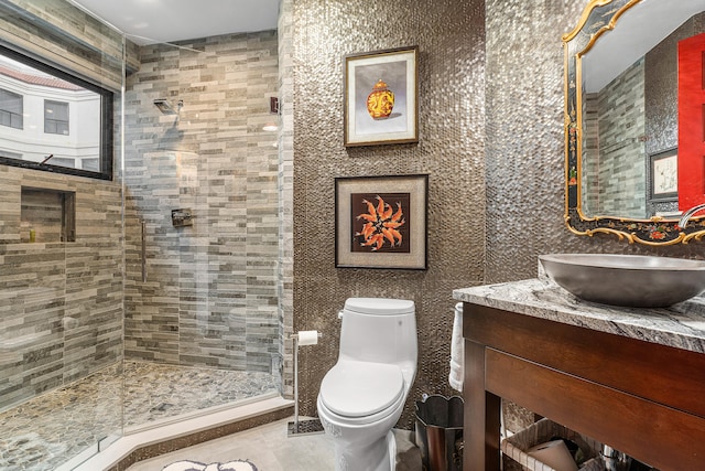 bathroom featuring vanity, a shower with shower door, and toilet