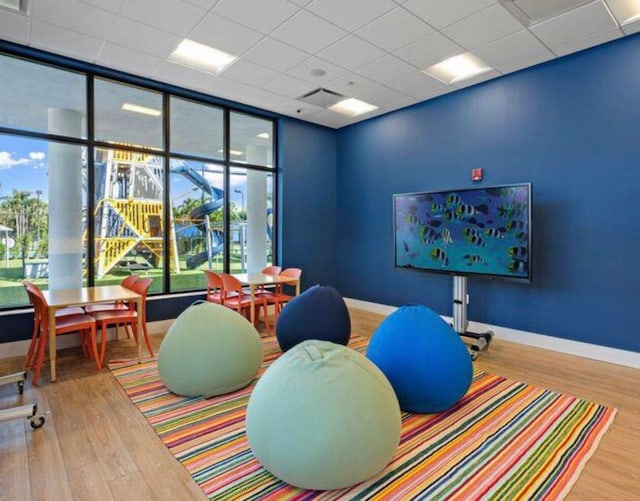 rec room with a drop ceiling and wood-type flooring