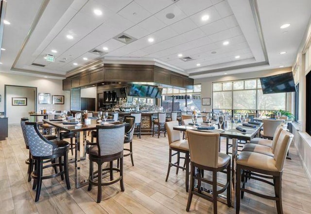 dining room featuring a tray ceiling and light hardwood / wood-style floors