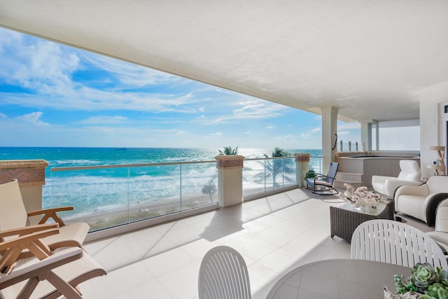 balcony with a water view, a view of the beach, and an outdoor hangout area