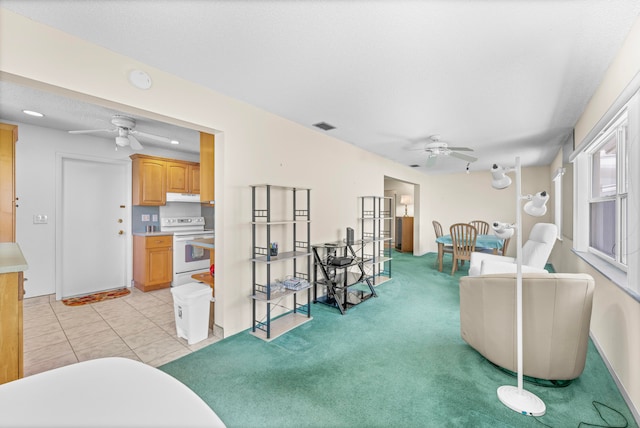 living room with light carpet, a textured ceiling, and ceiling fan