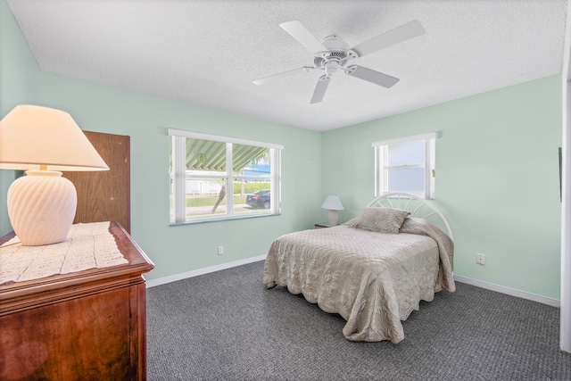 carpeted bedroom featuring ceiling fan and a textured ceiling