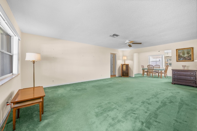 interior space featuring ceiling fan, carpet floors, and a textured ceiling