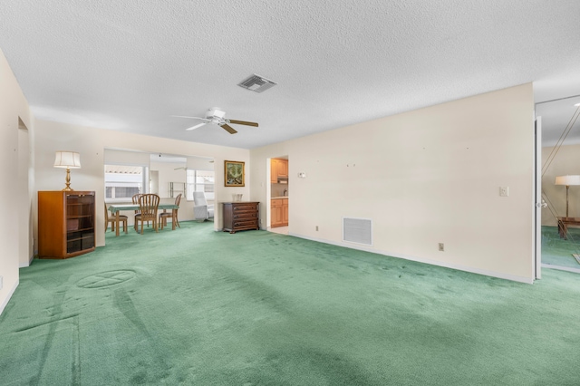 miscellaneous room with ceiling fan, a textured ceiling, and carpet flooring