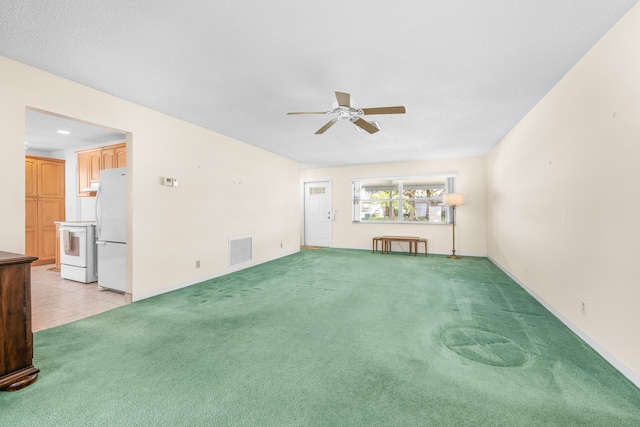 carpeted spare room featuring ceiling fan and a textured ceiling