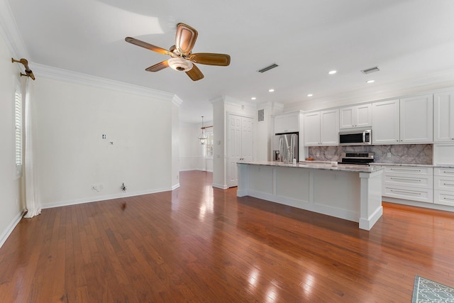 kitchen featuring stainless steel appliances, white cabinetry, a center island with sink, and hardwood / wood-style floors