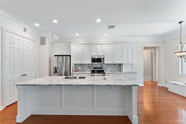 kitchen with an island with sink, white cabinetry, hardwood / wood-style floors, and stainless steel appliances