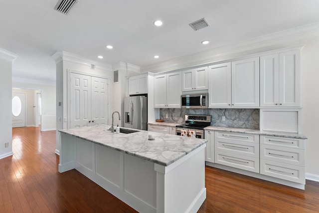 kitchen featuring sink, a center island with sink, white cabinetry, stainless steel appliances, and dark hardwood / wood-style flooring