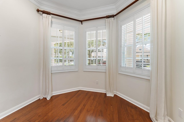 unfurnished room featuring hardwood / wood-style floors, ornamental molding, and a healthy amount of sunlight