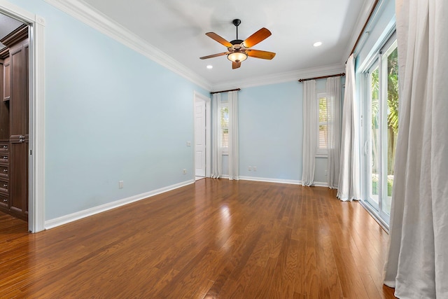 empty room with ceiling fan, ornamental molding, plenty of natural light, and hardwood / wood-style floors