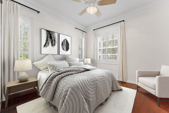 bedroom with ceiling fan, crown molding, and dark wood-type flooring