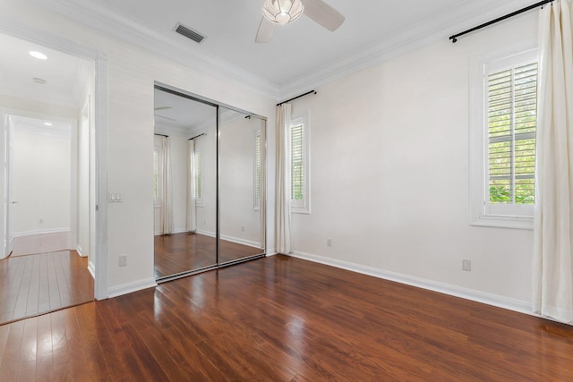 unfurnished bedroom featuring ceiling fan, a closet, crown molding, and dark hardwood / wood-style flooring