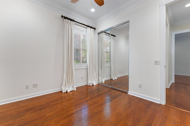 unfurnished bedroom featuring ornamental molding, wood-type flooring, a closet, and ceiling fan