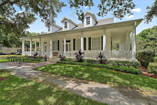 farmhouse inspired home with a front yard and covered porch