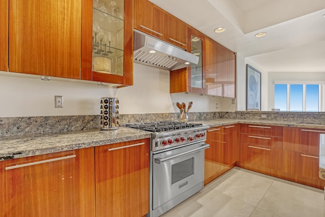 kitchen with designer stove, light tile patterned floors, and light stone counters