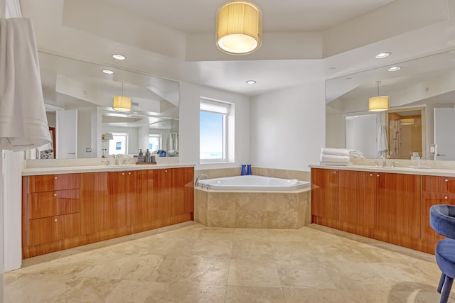 bathroom with vanity and a relaxing tiled tub