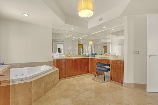 bathroom featuring a relaxing tiled tub and vanity