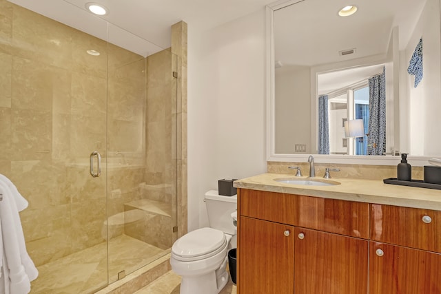 bathroom with vanity, toilet, and an enclosed shower