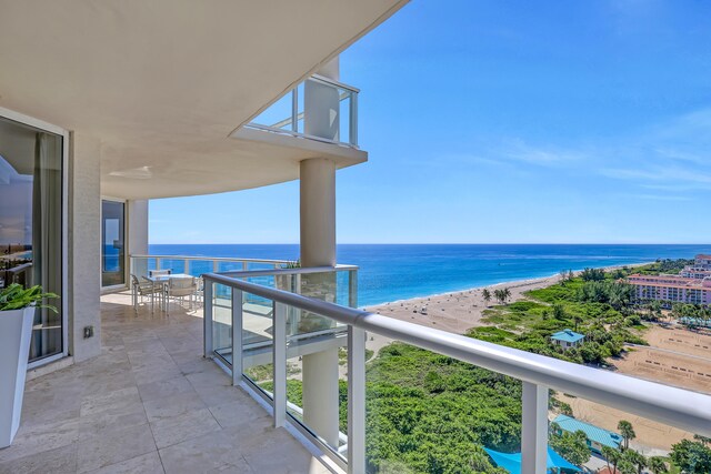 balcony featuring a water view and a beach view