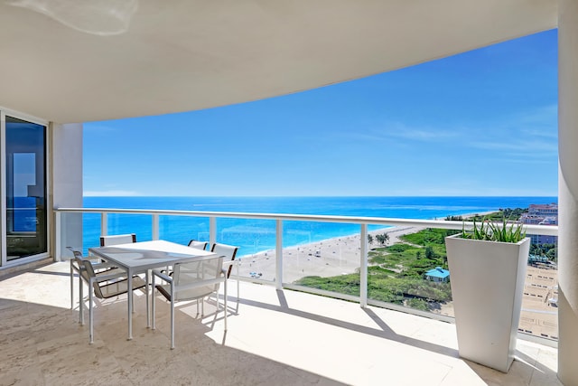 balcony featuring a view of the beach and a water view