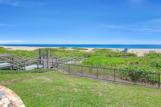 view of yard with a water view and a beach view