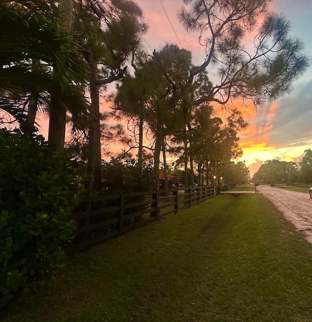 yard at dusk featuring a rural view