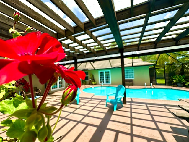 view of swimming pool featuring a lanai and a patio area