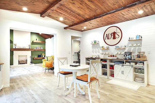 dining area featuring vaulted ceiling with beams, wooden walls, light hardwood / wood-style floors, and wood ceiling