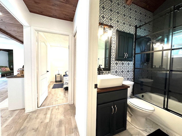 full bathroom featuring toilet, vaulted ceiling, combined bath / shower with glass door, and vanity