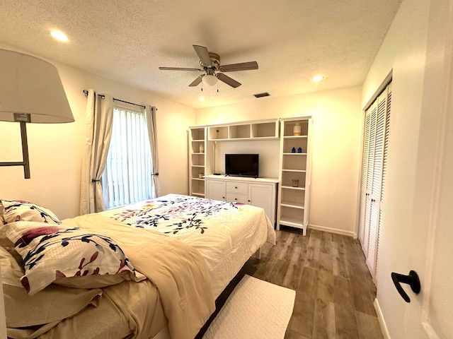 bedroom featuring a textured ceiling, ceiling fan, a closet, and dark hardwood / wood-style flooring