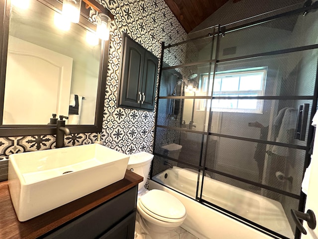 full bathroom with vaulted ceiling, toilet, shower / bath combination with glass door, and vanity