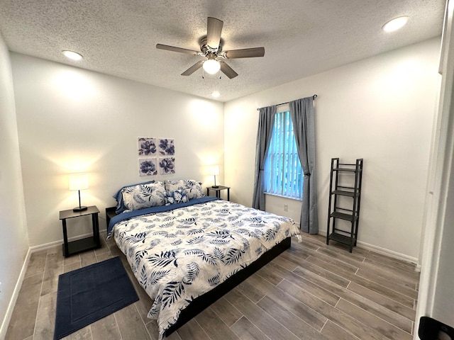 bedroom featuring ceiling fan, hardwood / wood-style floors, and a textured ceiling