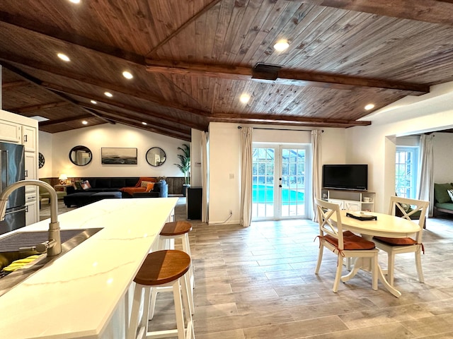 dining room with french doors, wood ceiling, lofted ceiling with beams, and light wood-type flooring