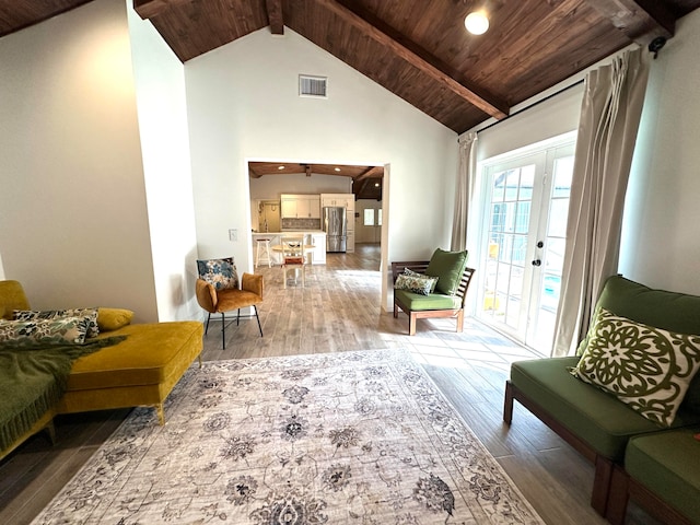 living area with high vaulted ceiling, beam ceiling, hardwood / wood-style floors, and wood ceiling