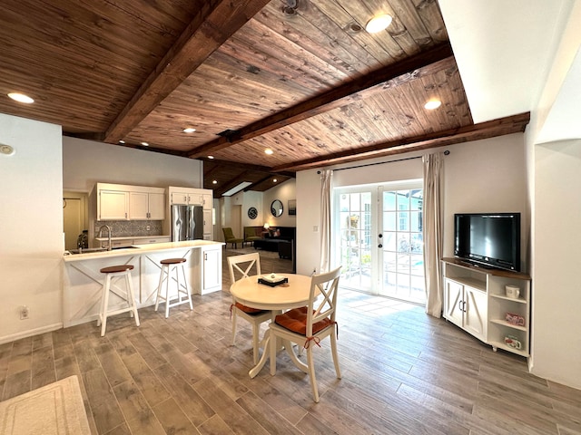 dining area featuring vaulted ceiling with beams, sink, wood ceiling, and hardwood / wood-style floors