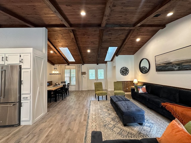 living room featuring an inviting chandelier, vaulted ceiling with skylight, light wood-type flooring, and wood ceiling