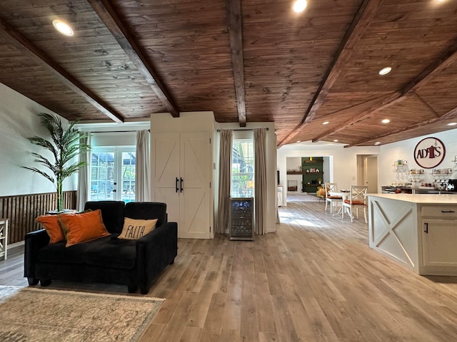 unfurnished living room featuring lofted ceiling with beams, light wood-type flooring, and wood ceiling