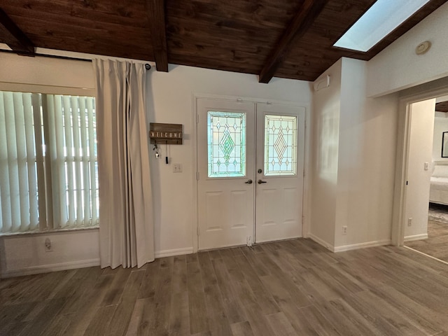 entrance foyer featuring wood-type flooring, wood ceiling, and lofted ceiling with skylight