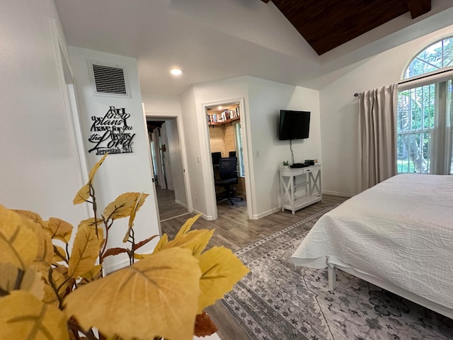 bedroom with wood-type flooring and vaulted ceiling