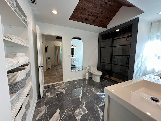 bathroom featuring lofted ceiling, hardwood / wood-style floors, vanity, and toilet