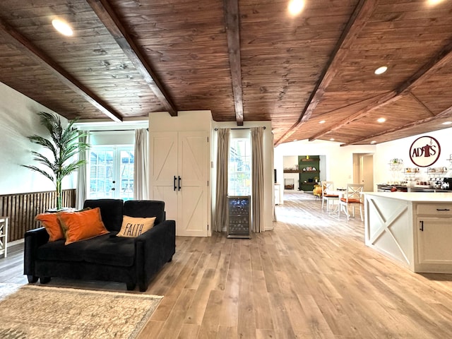 unfurnished living room featuring light hardwood / wood-style floors, wooden ceiling, and vaulted ceiling with beams