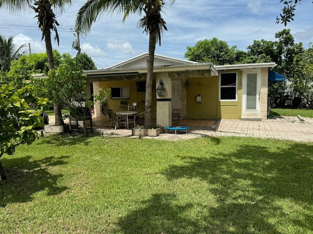 rear view of house featuring a patio and a lawn