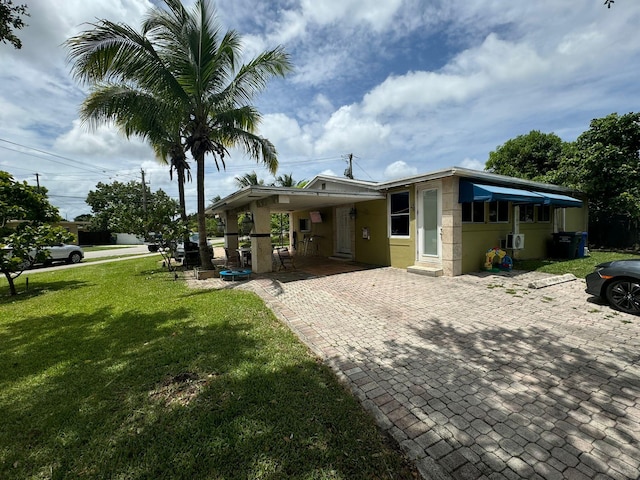 view of front of home with a front lawn and a carport