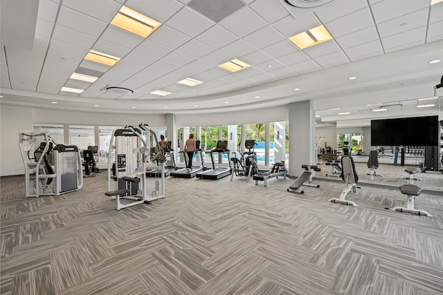 exercise room featuring a paneled ceiling and carpet