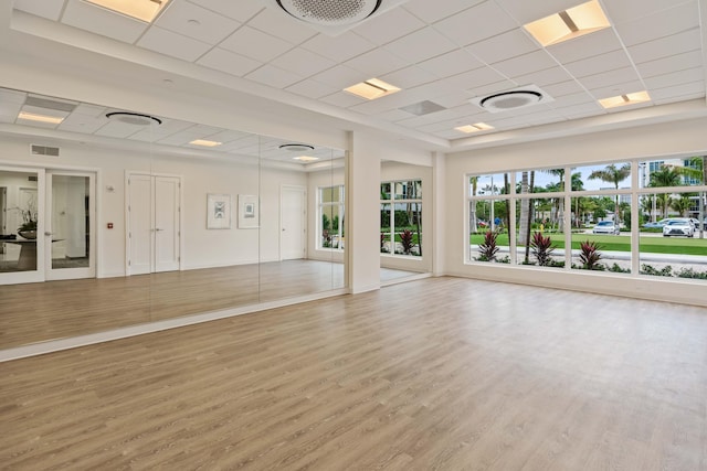 workout area featuring wood-type flooring and a paneled ceiling