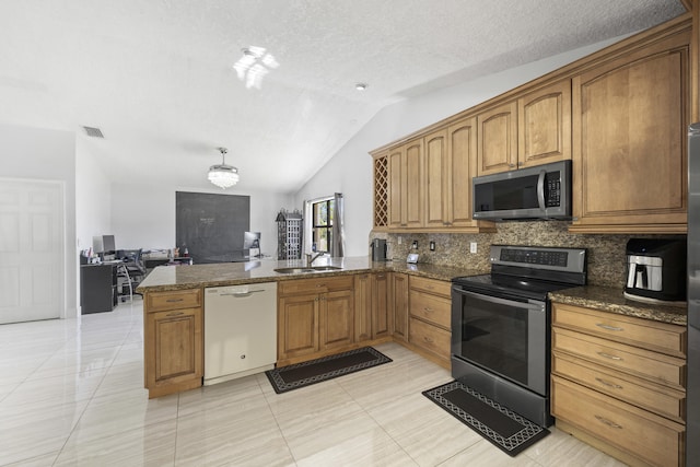 kitchen featuring stainless steel appliances, dark stone countertops, sink, and vaulted ceiling