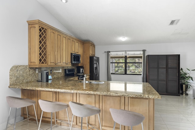 kitchen featuring lofted ceiling, sink, black appliances, and kitchen peninsula