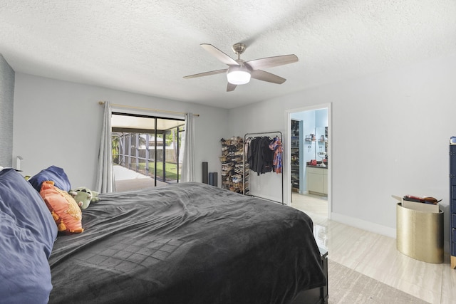 bedroom featuring access to exterior, ensuite bathroom, a textured ceiling, and ceiling fan